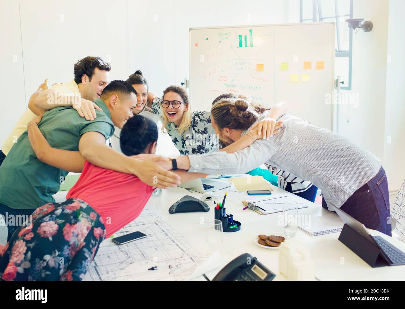 Enthusiastic architects bonding in huddle in conference room meeting Stock Photo