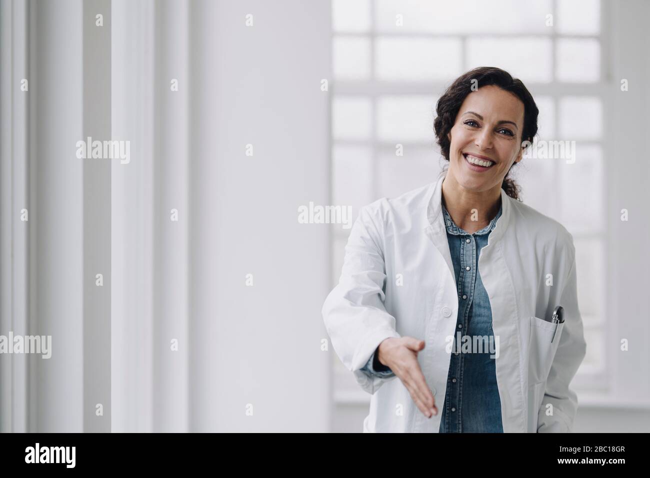 Female doctor reaching out hand for greeting Stock Photo