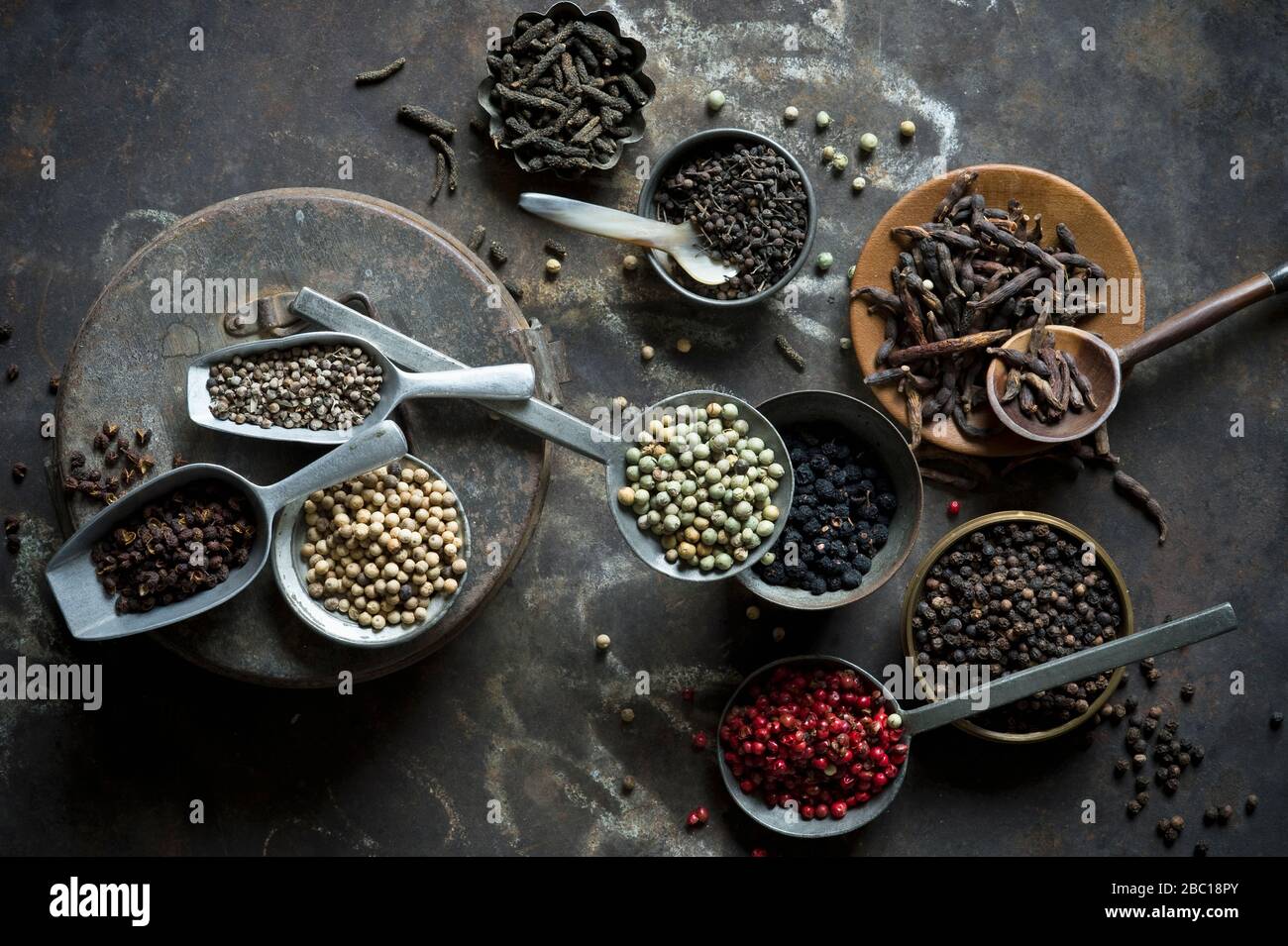 Bowls, ladles and scoops of various peppers Stock Photo