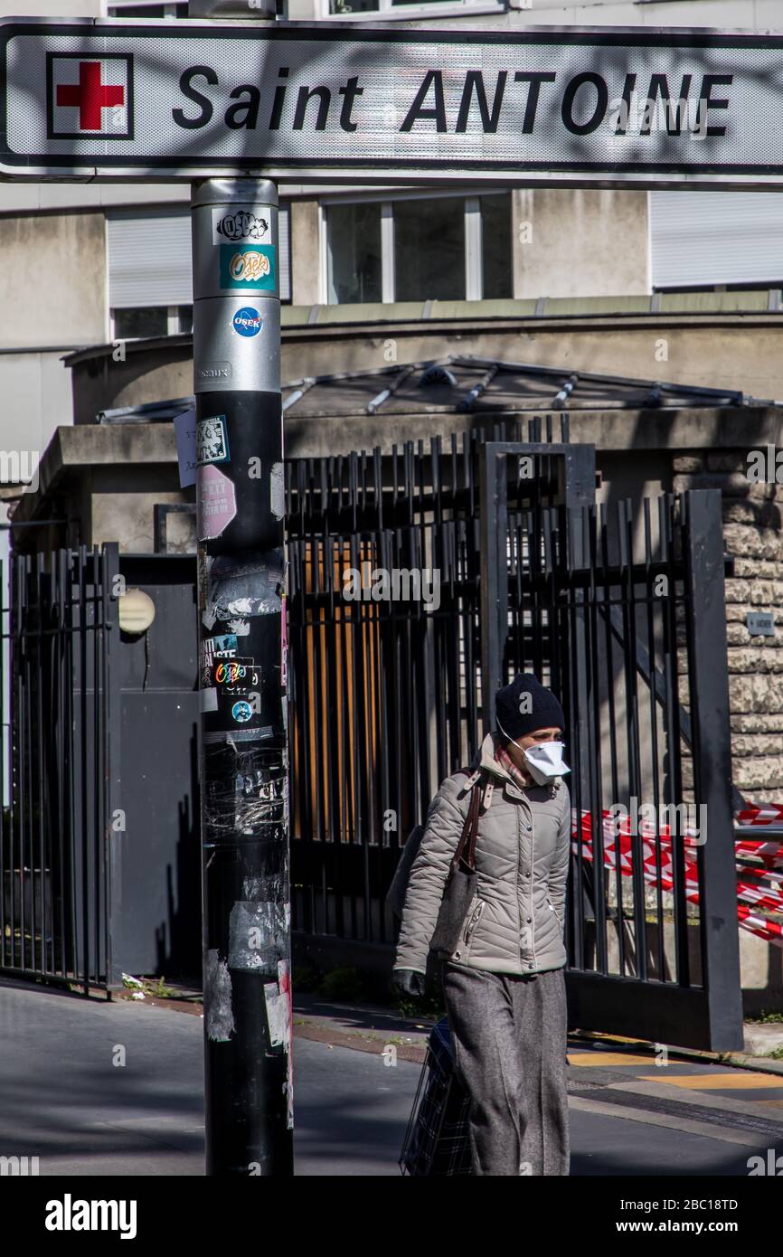 WOMAN WITH A MASK IN FRONT OF THE SAINT ANTOINE HOSPITAL, PARIS, ILEDE