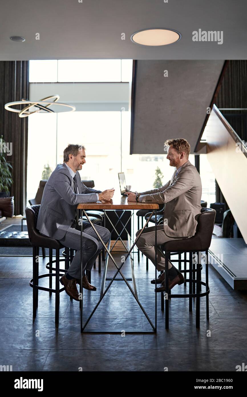 Two businessmen having a meeting in hotel lobby Stock Photo - Alamy
