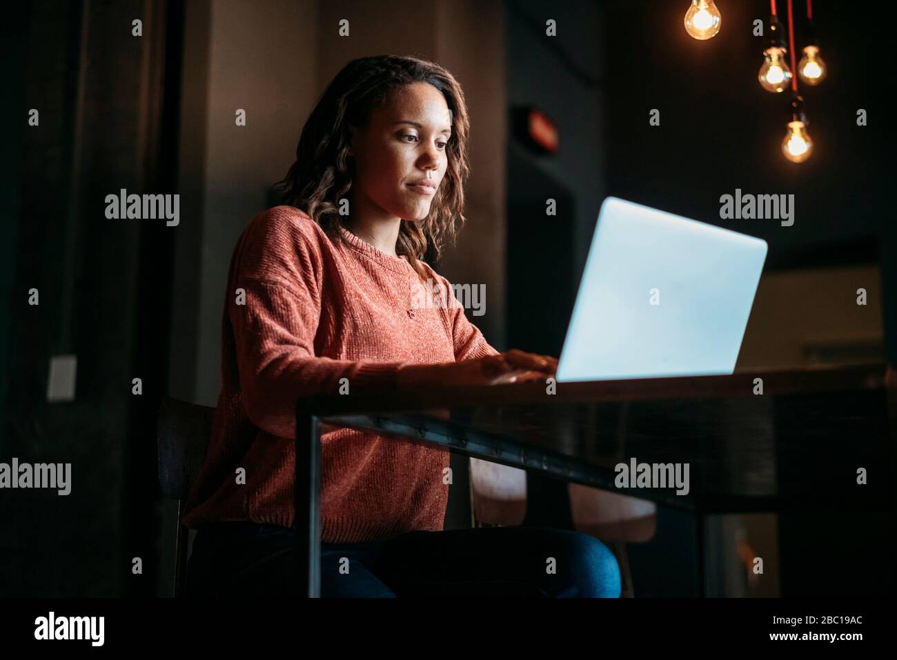 Young woman using laptop in a cafe Stock Photo - Alamy