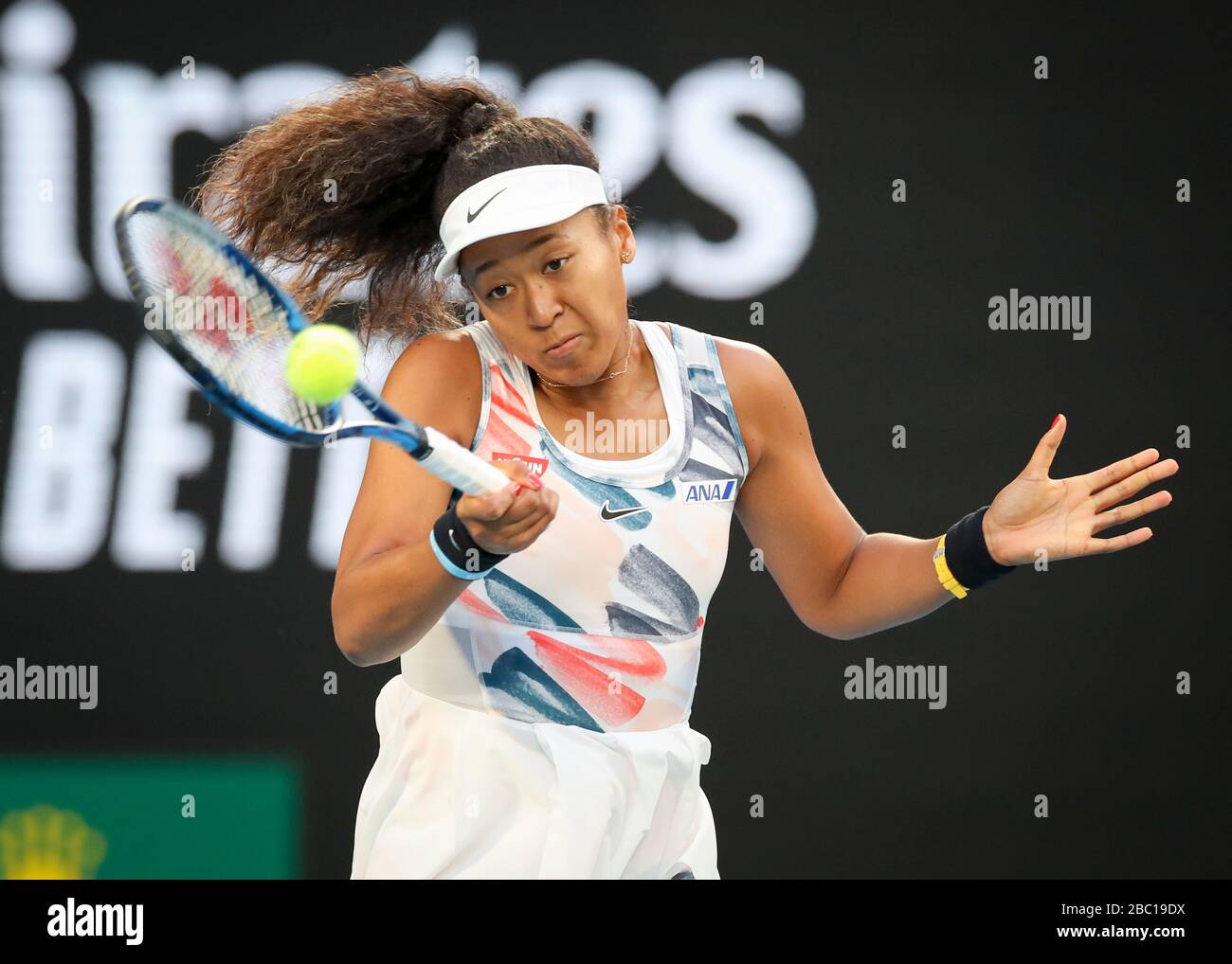 Japanese tennis player Naomi Osaka playing a high forehand shot in Australian Open 2020 tennis
