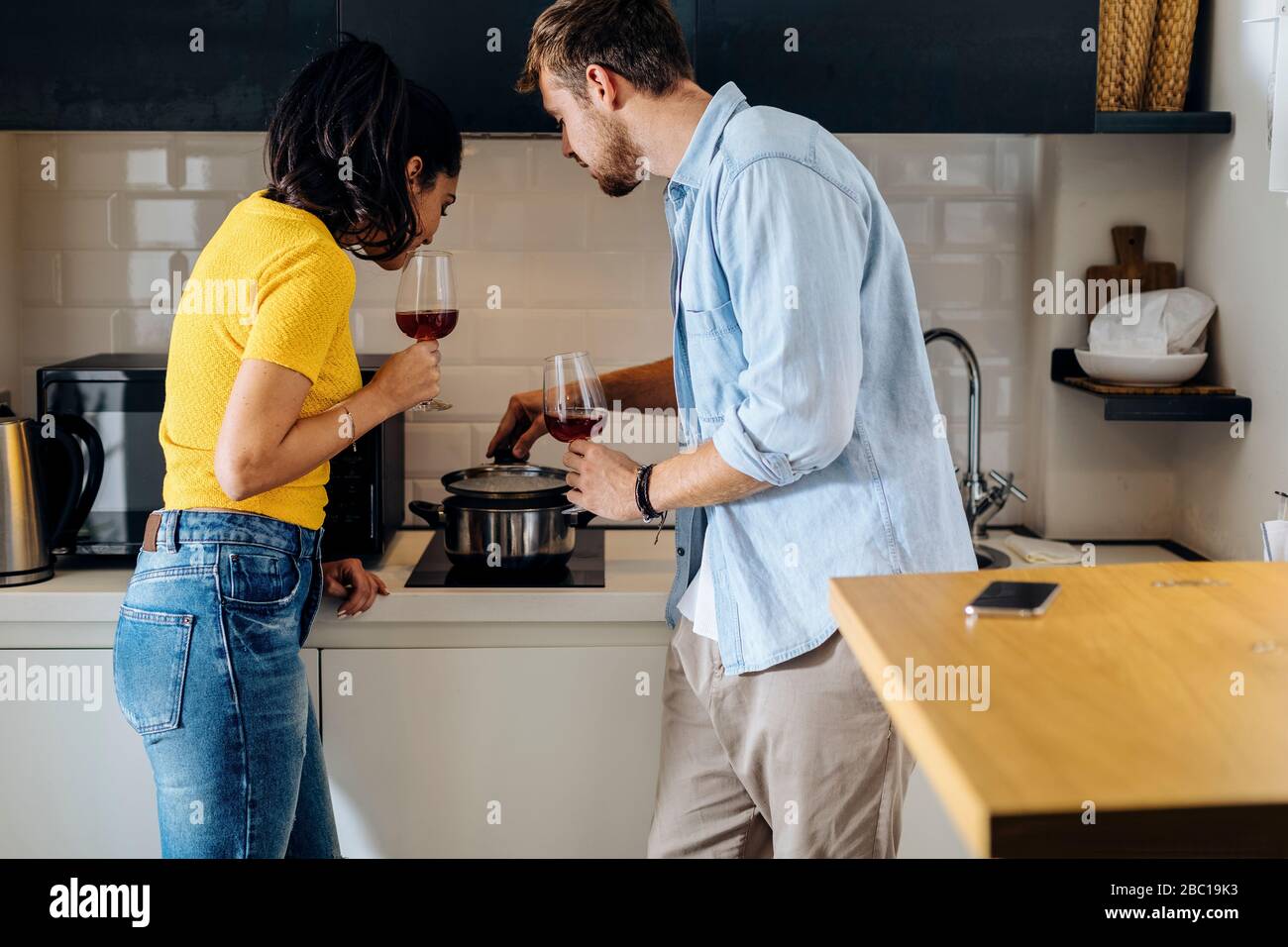 Young Couple Cooking And Drinking Wine In The Kitchen At Home Together Stock Photo Alamy