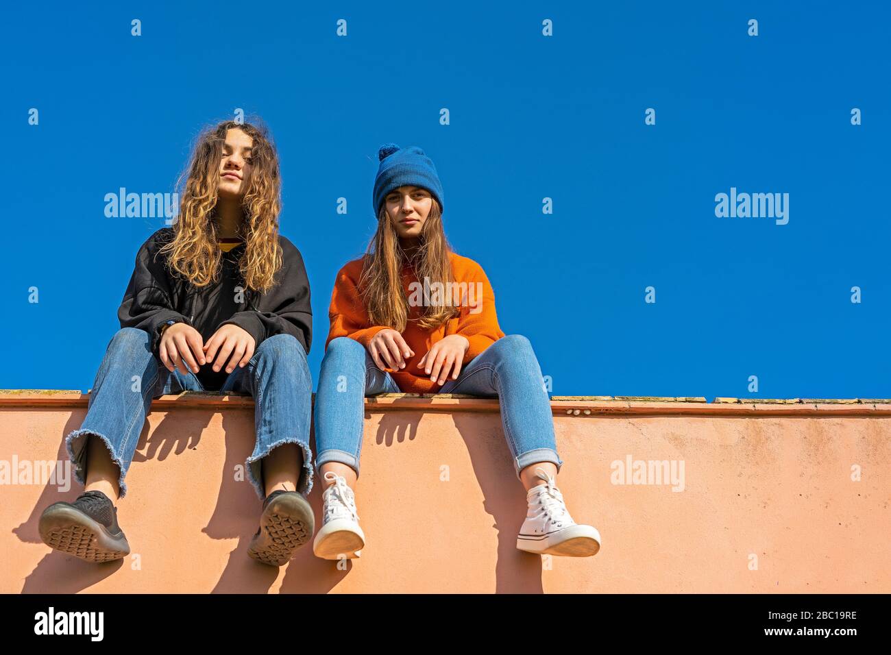 Girls sitting on a wall hi-res stock photography and images - Alamy