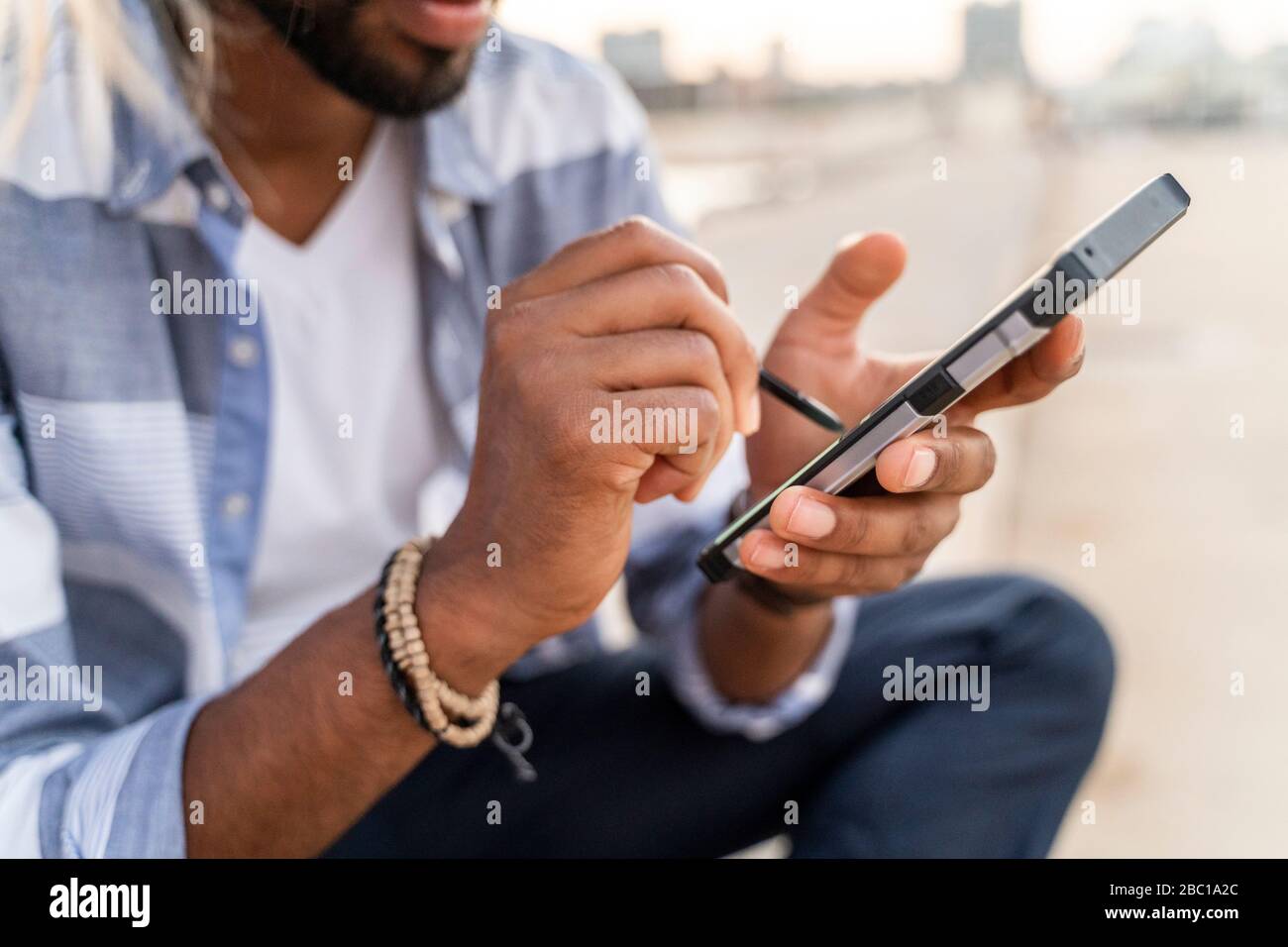 Close-up of man using smartphone outdoors Stock Photo