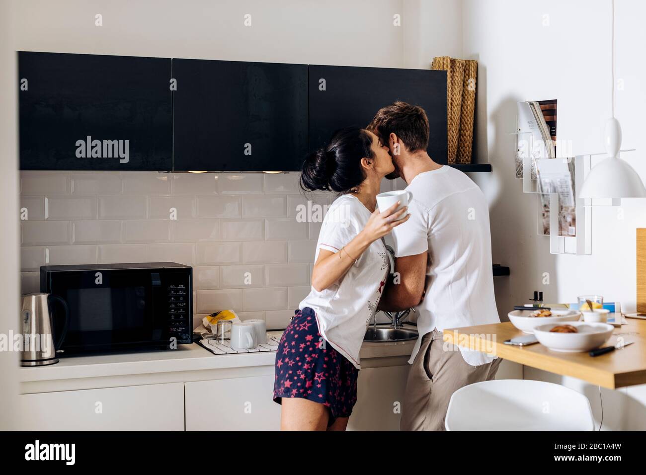 Affectionate young couple in the morning in kitchen Stock Photo