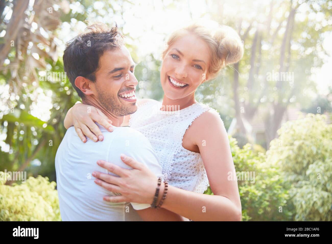 Portrait smiling young couple hugging in park Stock Photo