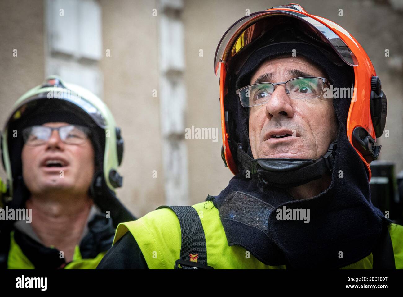 COMMANDER OF THE RESCUE OPERATIONS(ORANGE HELMET) WITH HIS MEN, INTERVENTION FOR AN APARTMENT FIRE IN THE CITY CENTER, FIREFIGHTERS FROM THE EMERGENCY SERVICES, AUXERRE, YONNE, FRANCE Stock Photo