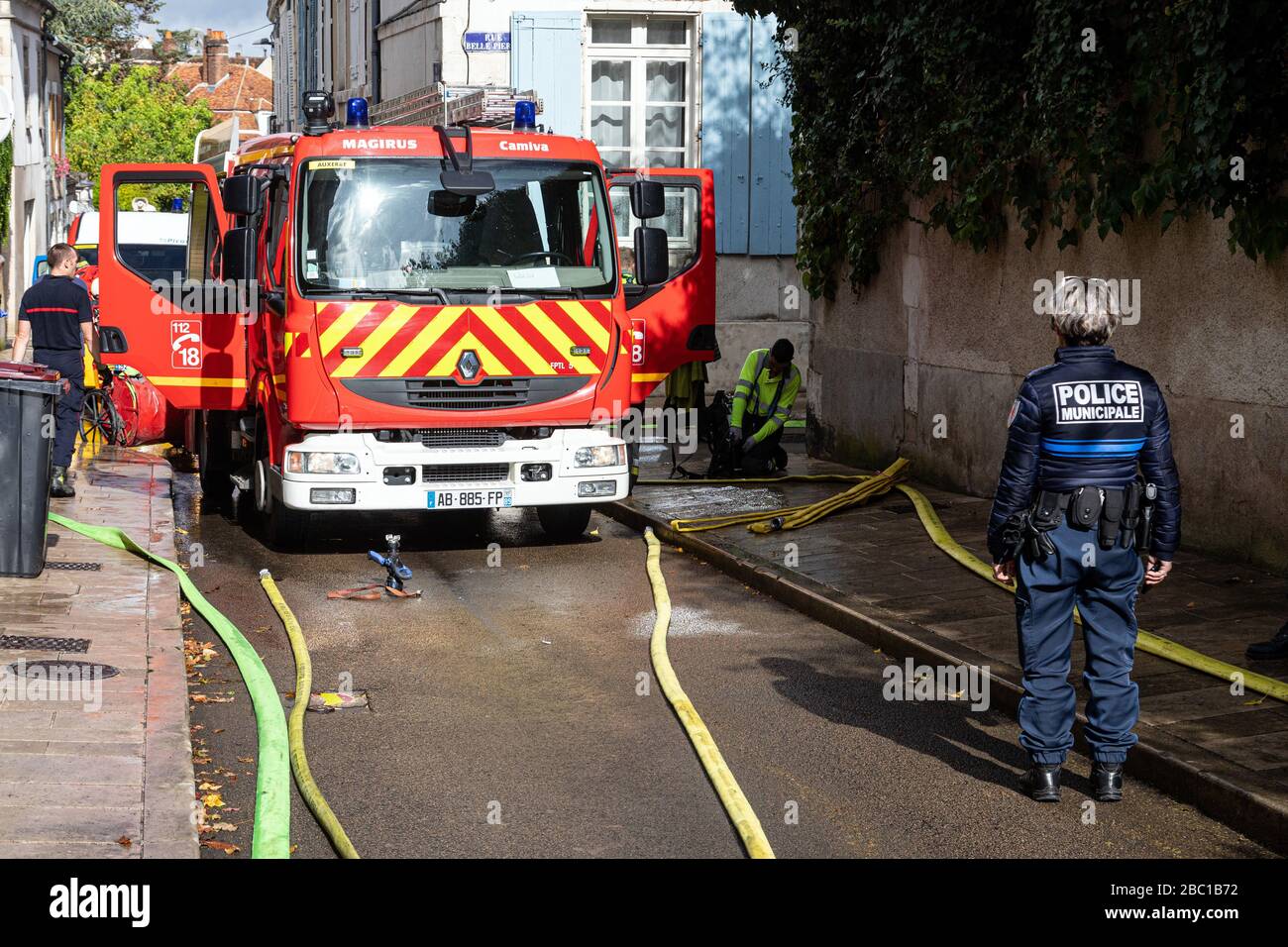 OFFICER FROM THE MUNICIPAL POLICE DURING AND INTERVENTION FOR AN APARTMENT FIRE IN THE CITY CENTER, FIREFIGHTERS FROM THE EMERGENCY SERVICES, AUXERRE, YONNE, FRANCE SPPF5199.jpg Stock Photo