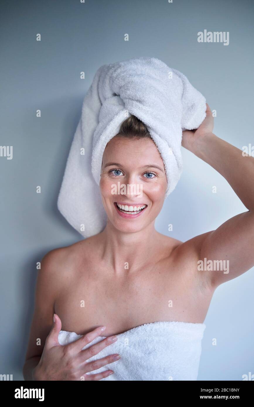 Portrait of happy young woman with her head wrapped in a towel Stock ...