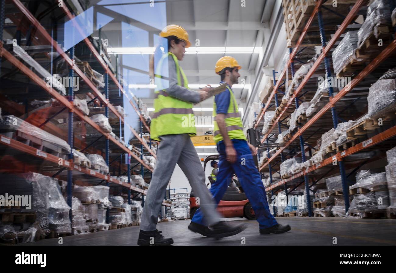 Workers with clipboard walking in warehouse Stock Photo