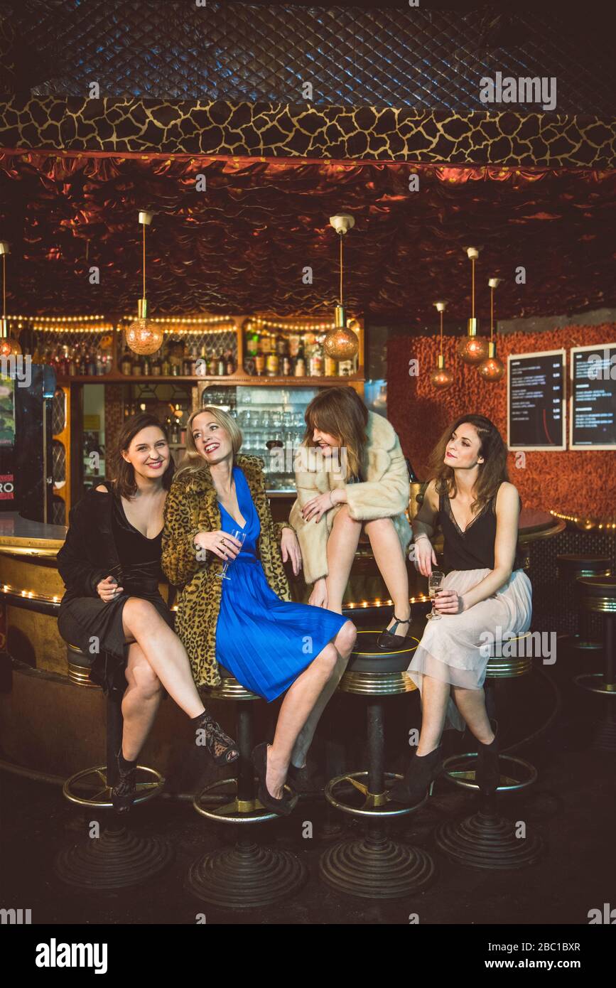 Four happy women sitting at the bar in a club Stock Photo Alamy