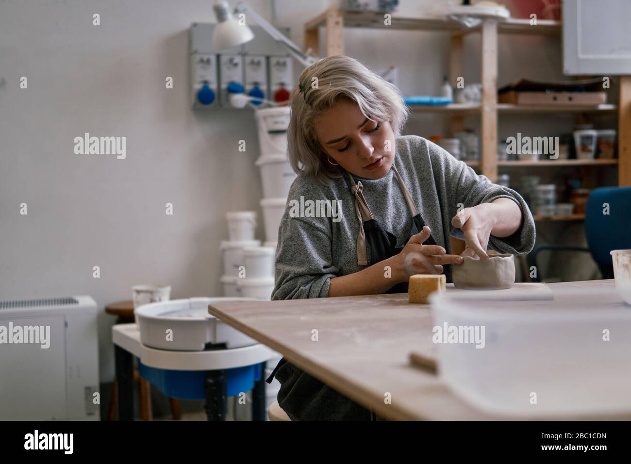 Young woman working on workpiece in pottery Stock Photo