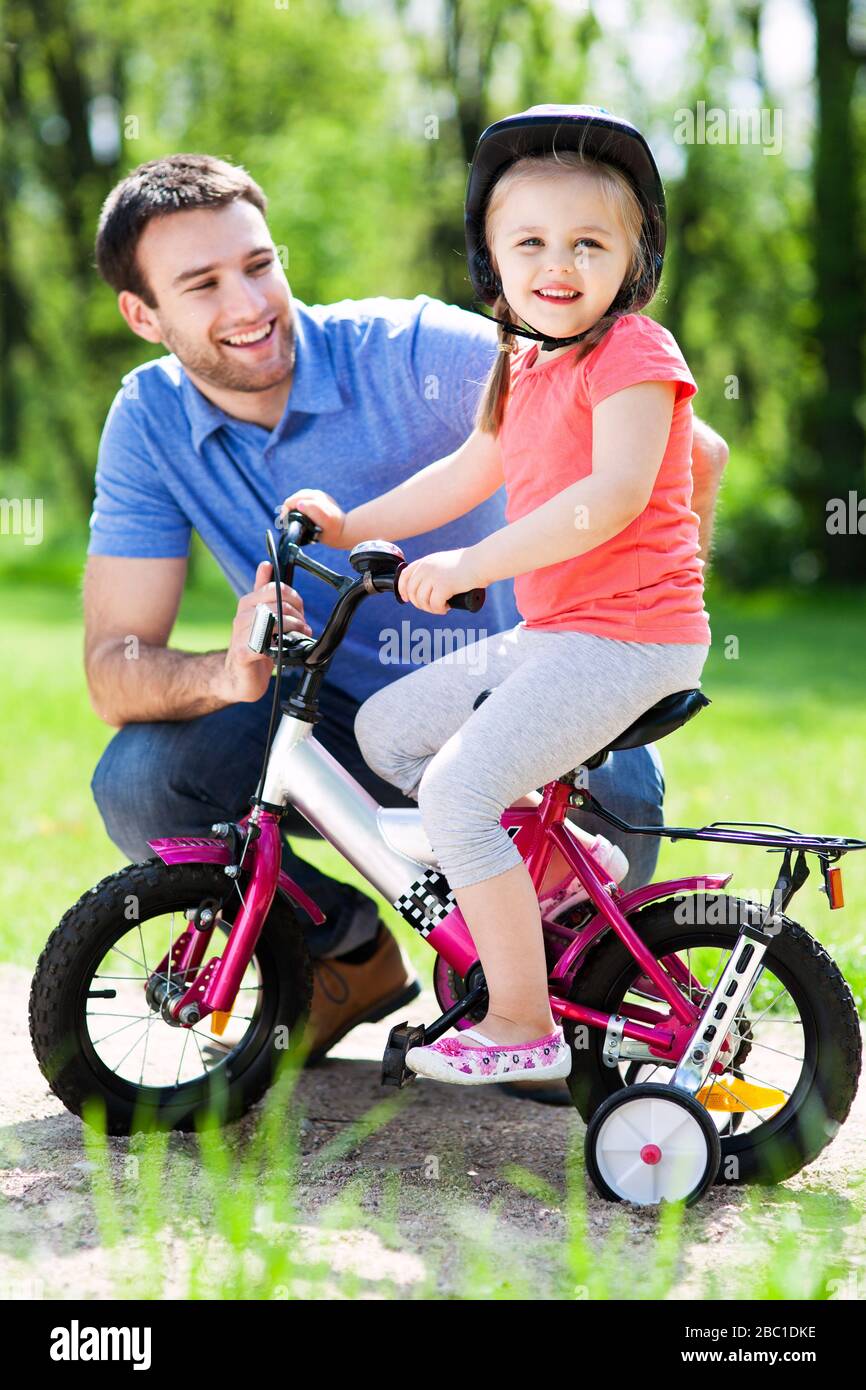 Young child learning how to ride her bike hires stock photography and