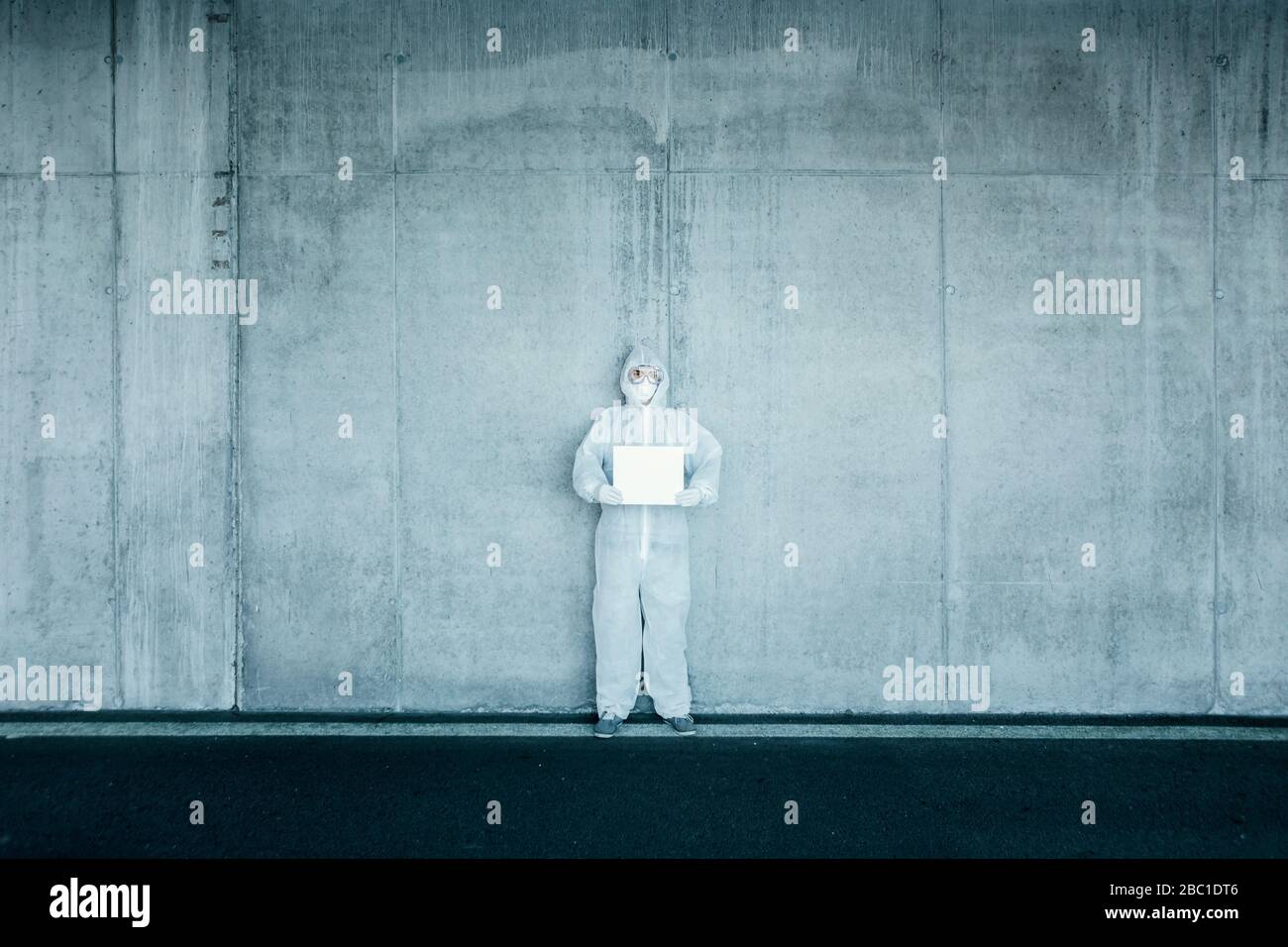 Man wearing protective clothing holding a blank sign Stock Photo