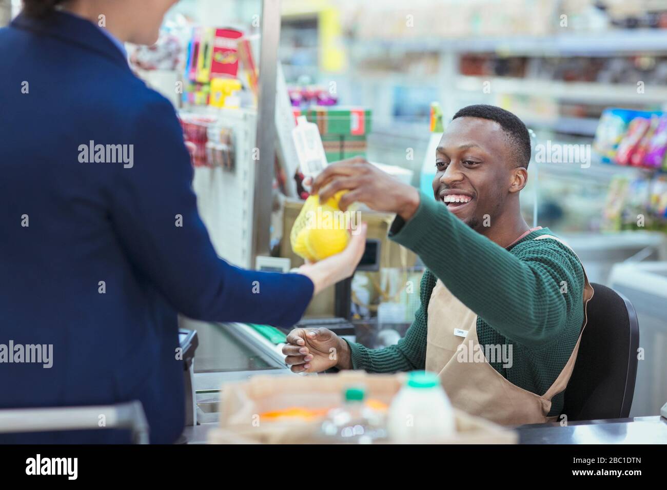 Cashier helping customer at supermarket checkout Stock Photo