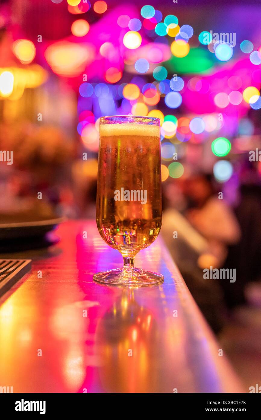 Full glass of beer standing on counter in nightclub Stock Photo