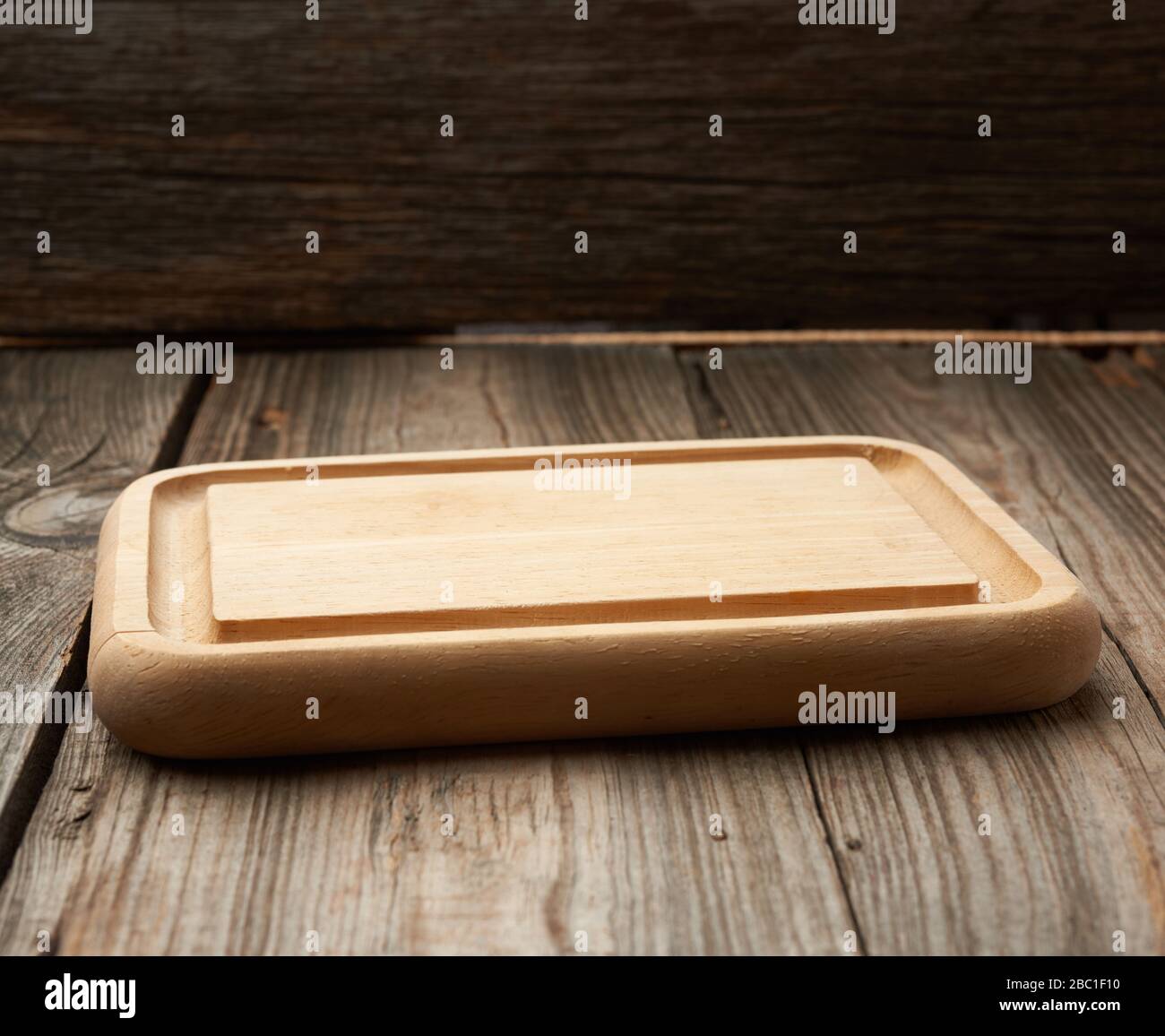 light beige rectangular empty cutting kitchen board on a wooden background from old boards, top view Stock Photo