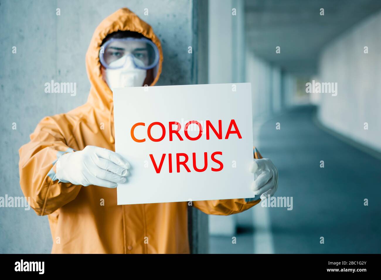 Portrait of man wearing protective clothing holding 'Corona virus' sign Stock Photo