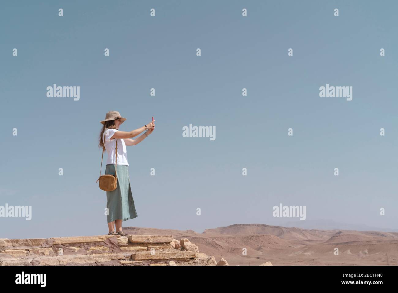 Young woman taking photos with smartphone, Ouarzazate, Morocco Stock Photo