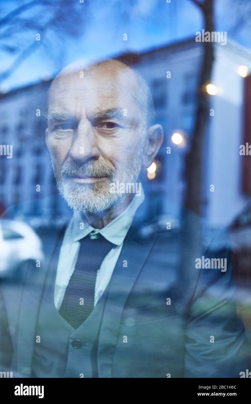Senior businessman, looking out of window Stock Photo