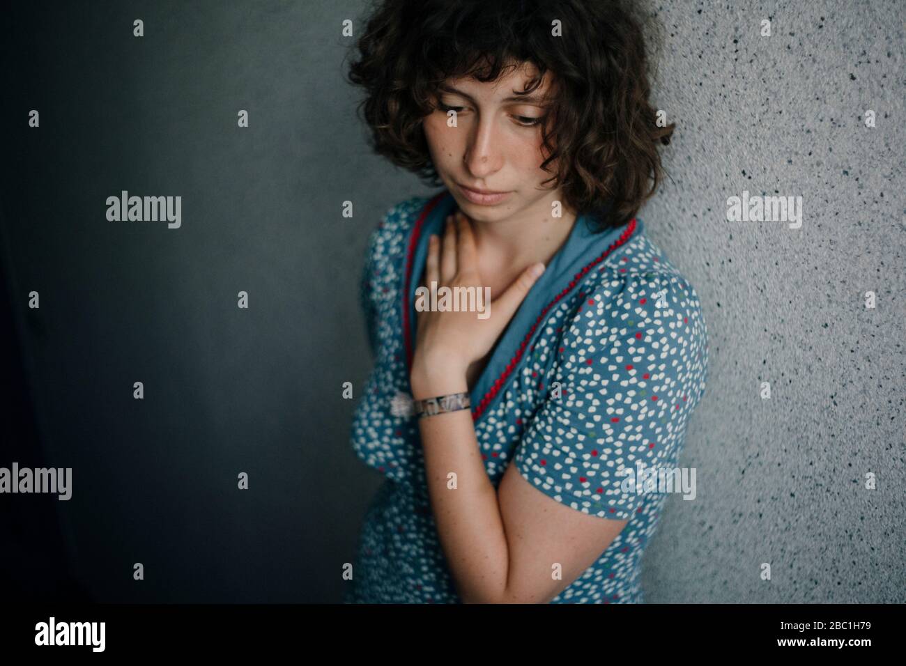 Portrait of sad young woman leaning against wall Stock Photo