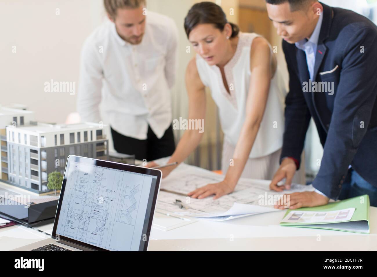 Architects discussing blueprints in meeting Stock Photo