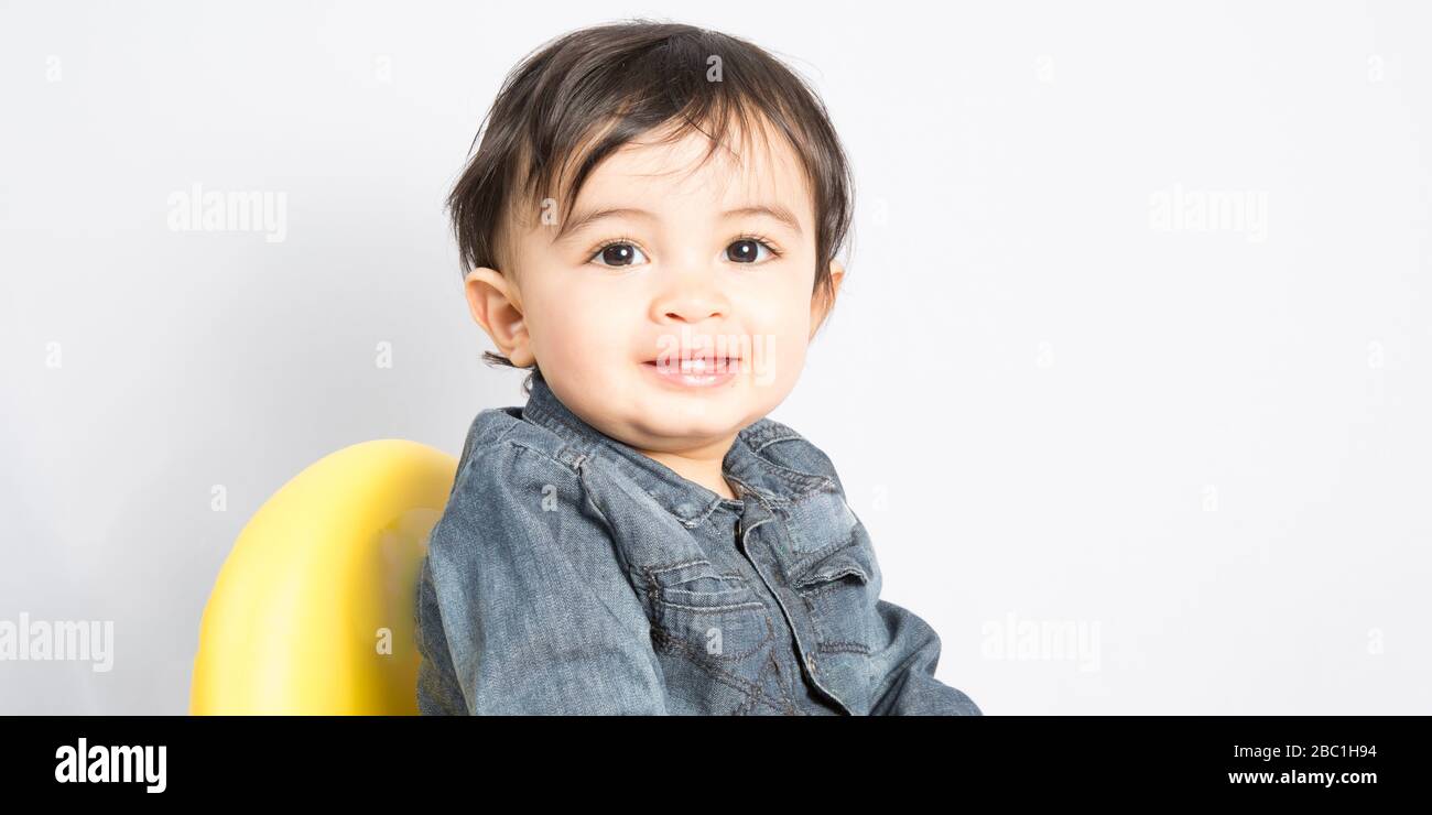Photo of adorable young happy boy wearing shirt looking at camera over ...