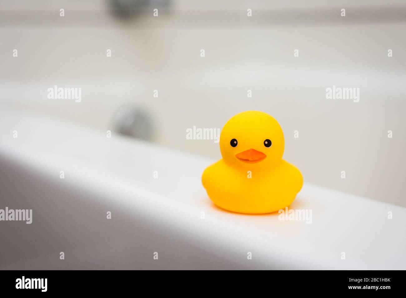Miniature Baby Rubber Duck On The Ledge Of White Bath Tub Stock Photo Alamy