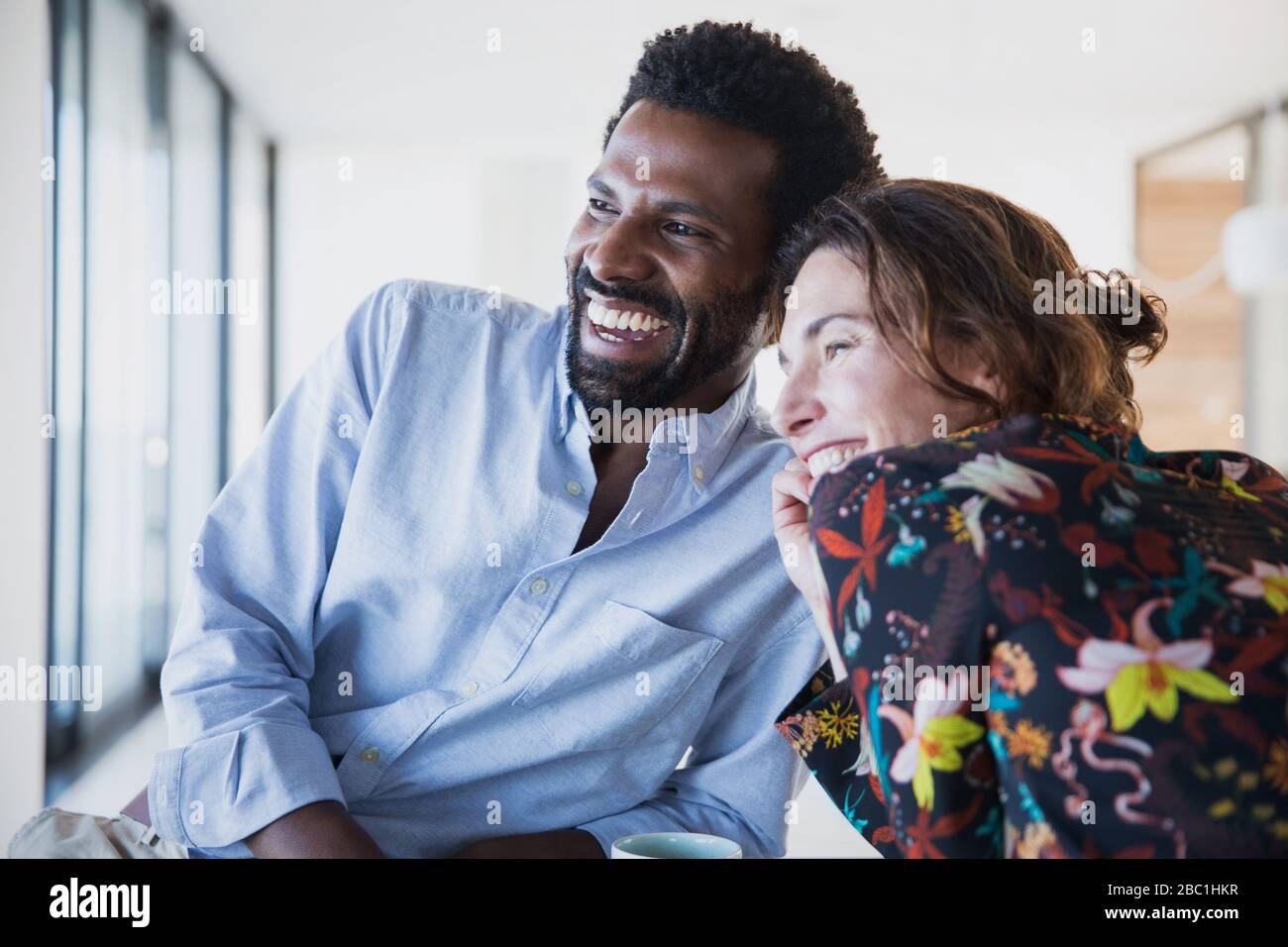 Smiling, enthusiastic multi-ethnic couple looking away Stock Photo