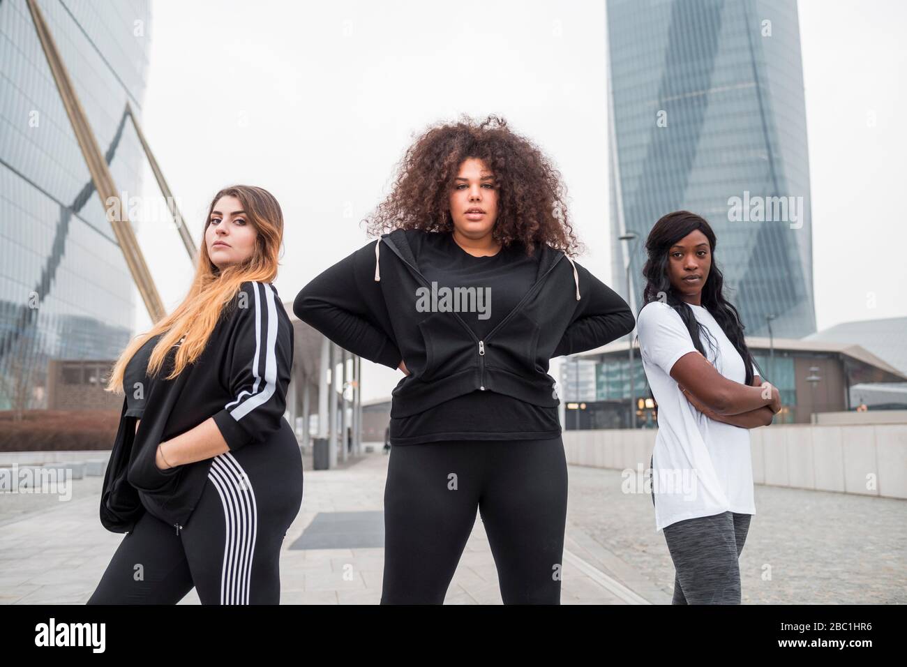 Three sportive young women posing in the city Stock Photo