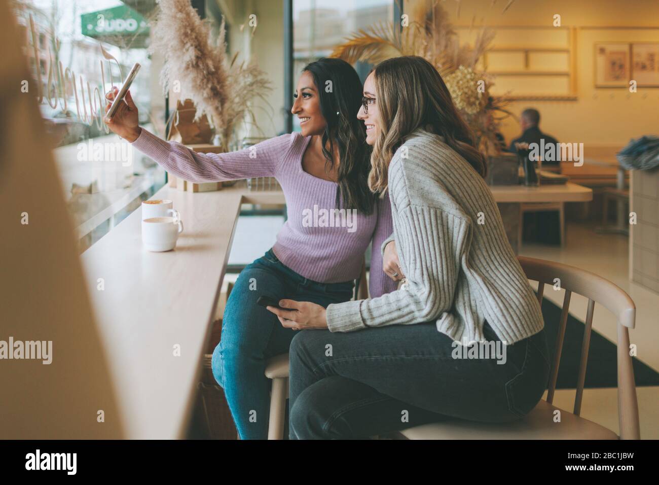 Two women taking a selfie in a cafe Stock Photo