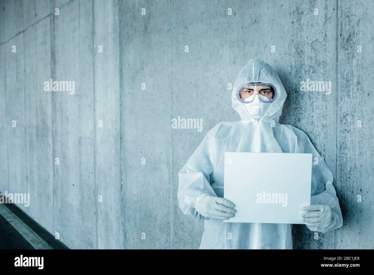 Portrait of man wearing protective clothing holding a blank sign Stock Photo