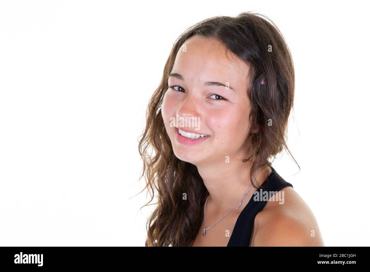 Portrait of young happy teenage girl smiling in white copy space ...