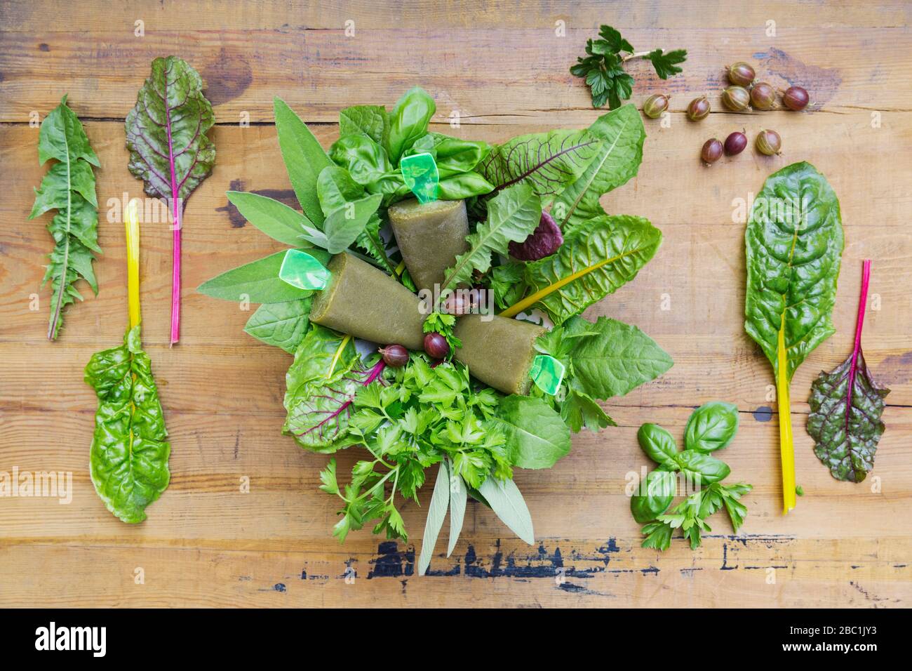 Overhead view of homemade green vegetables and herb popsicles on wooden table Stock Photo
