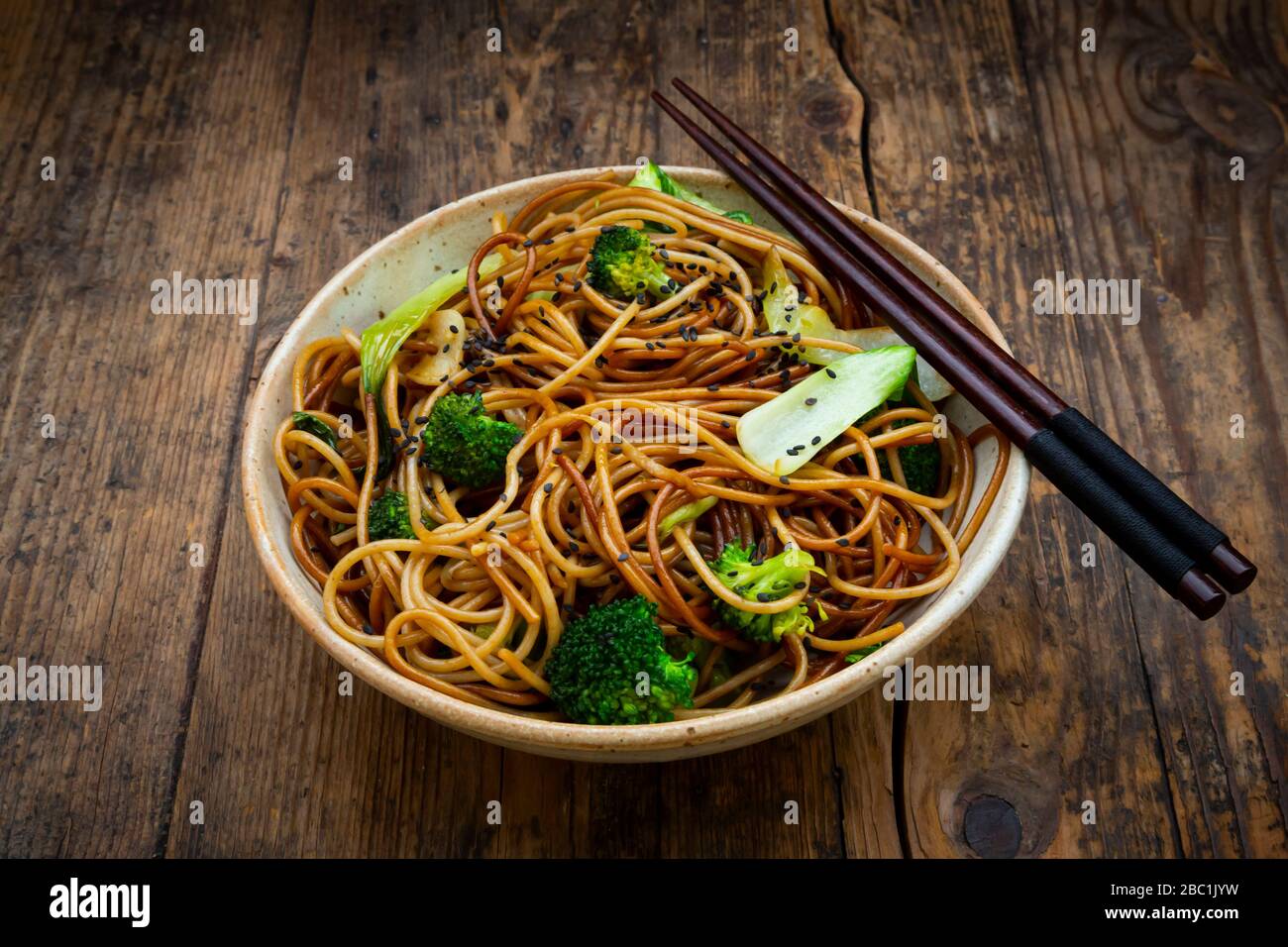 Bowl of Japanese soba noodles with bok choy, broccolies, soy sauce and