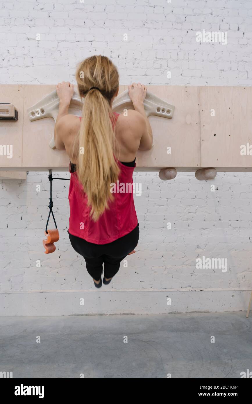 Woman doing pull-ups before climbing Stock Photo