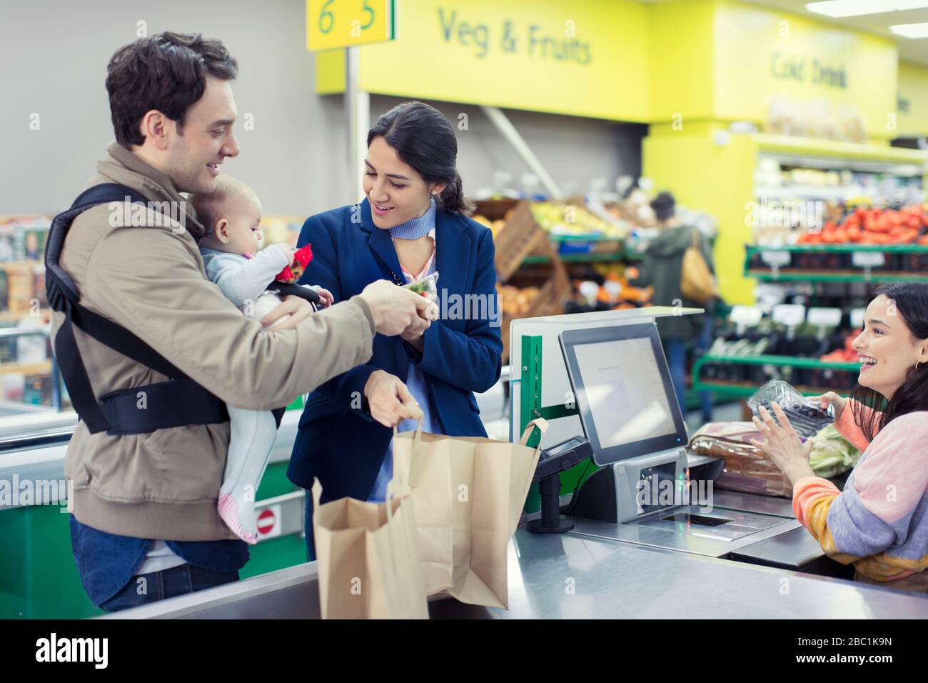 Young family at supermarket checkout Stock Photo