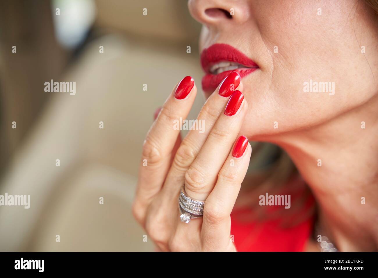 Crop view of mature woman with red lips and nails Stock Photo