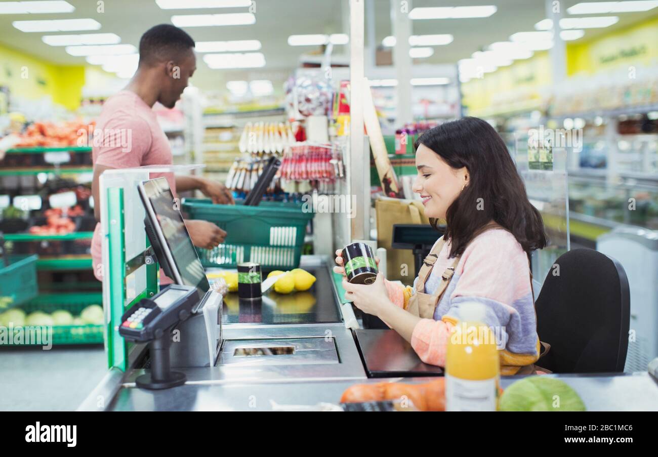 Cashier helping customer at supermarket checkout Stock Photo