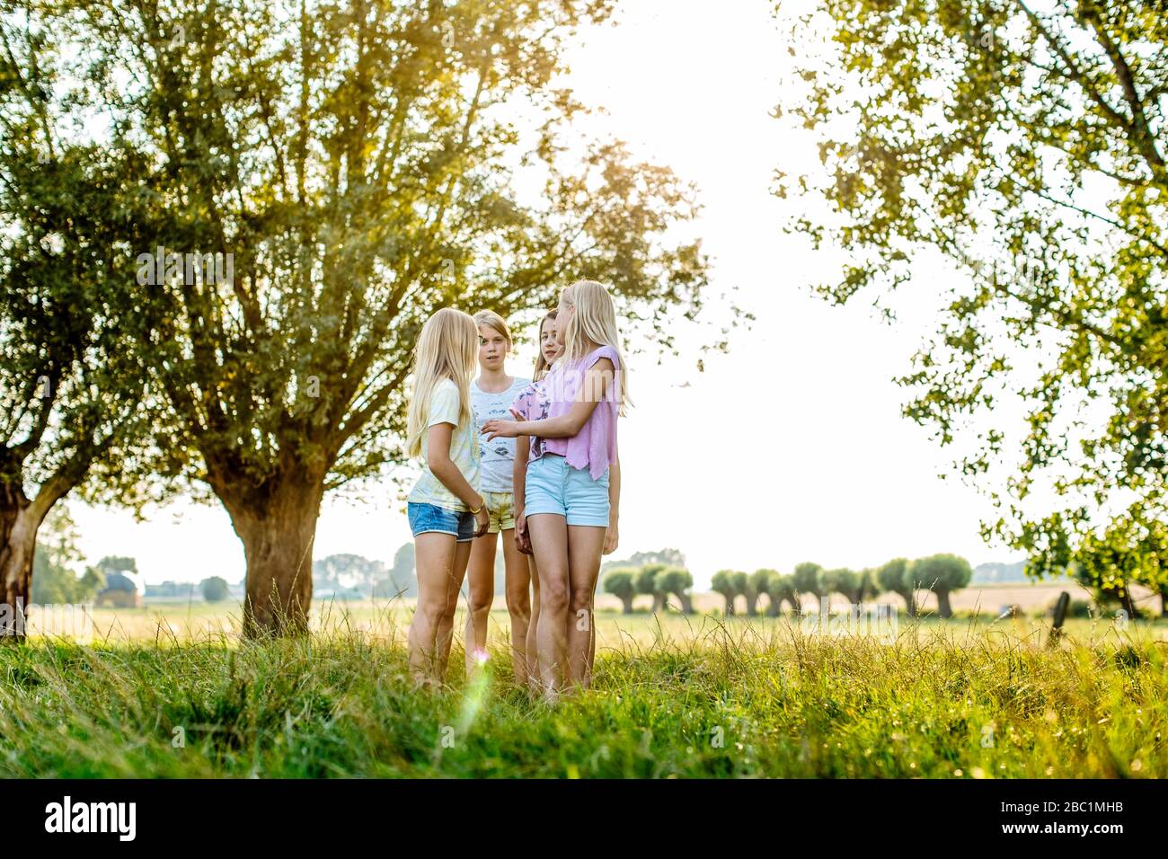 Girls standing on a field in the countryside Stock Photo - Alamy
