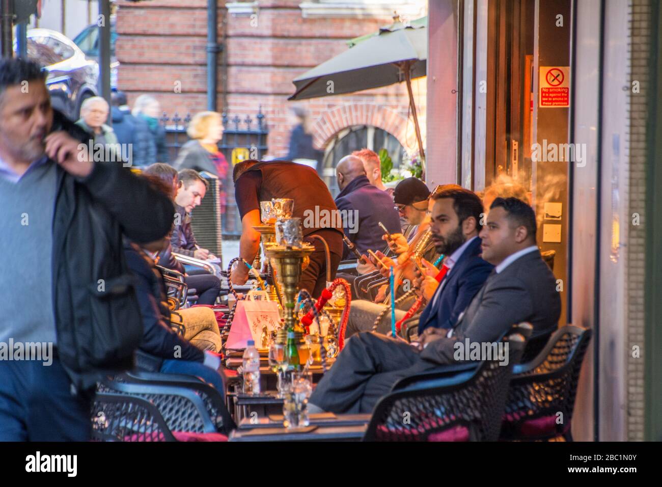 Business people smoking shisha outside lounge bar in Mayfair London