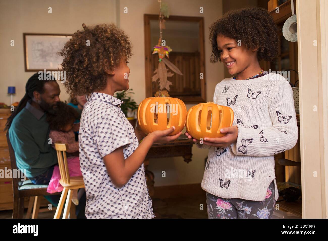 Happy brother and sister holding carved pumpkins Stock Photo