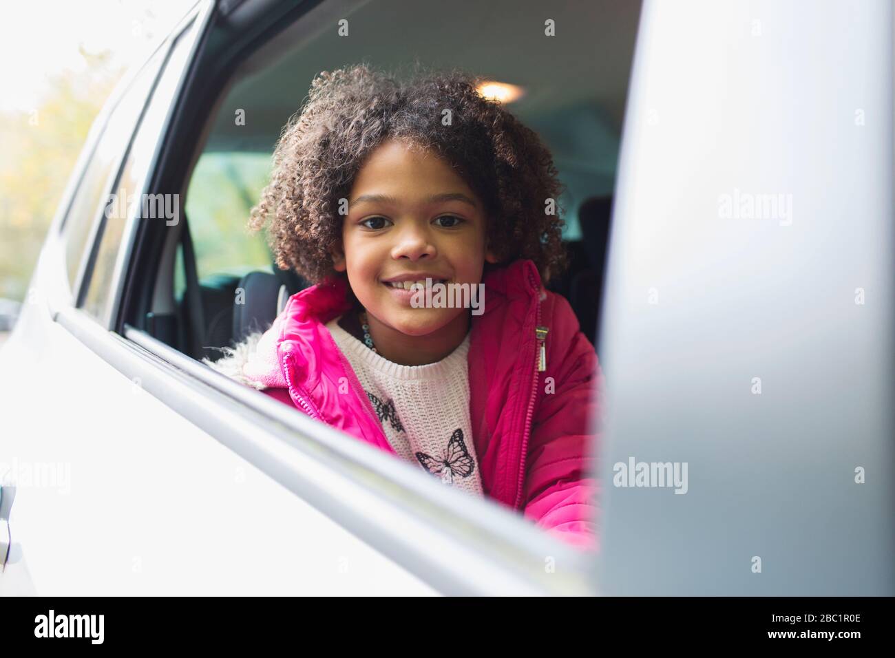 Portrait happy girl riding in back seat of car Stock Photo