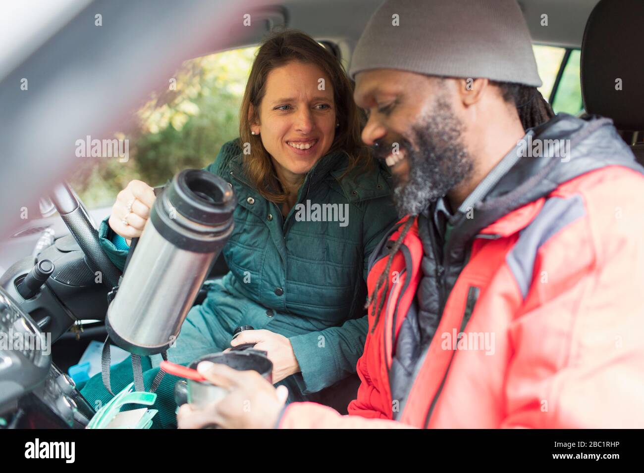 Happy couple drinking coffee in car Stock Photo