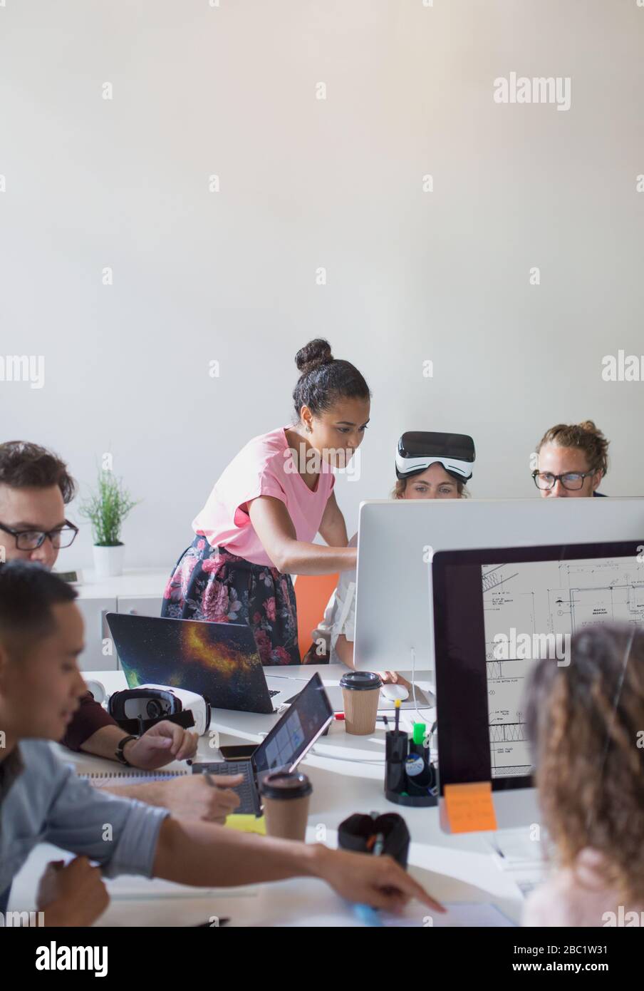 Computer programmers and designers working at computers in open plan office Stock Photo