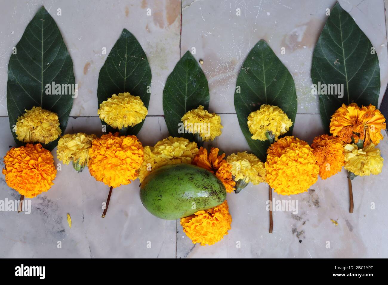 Swastika made using Marigold flowers for Ugadi with Clay Oil Lamp Stock Photo