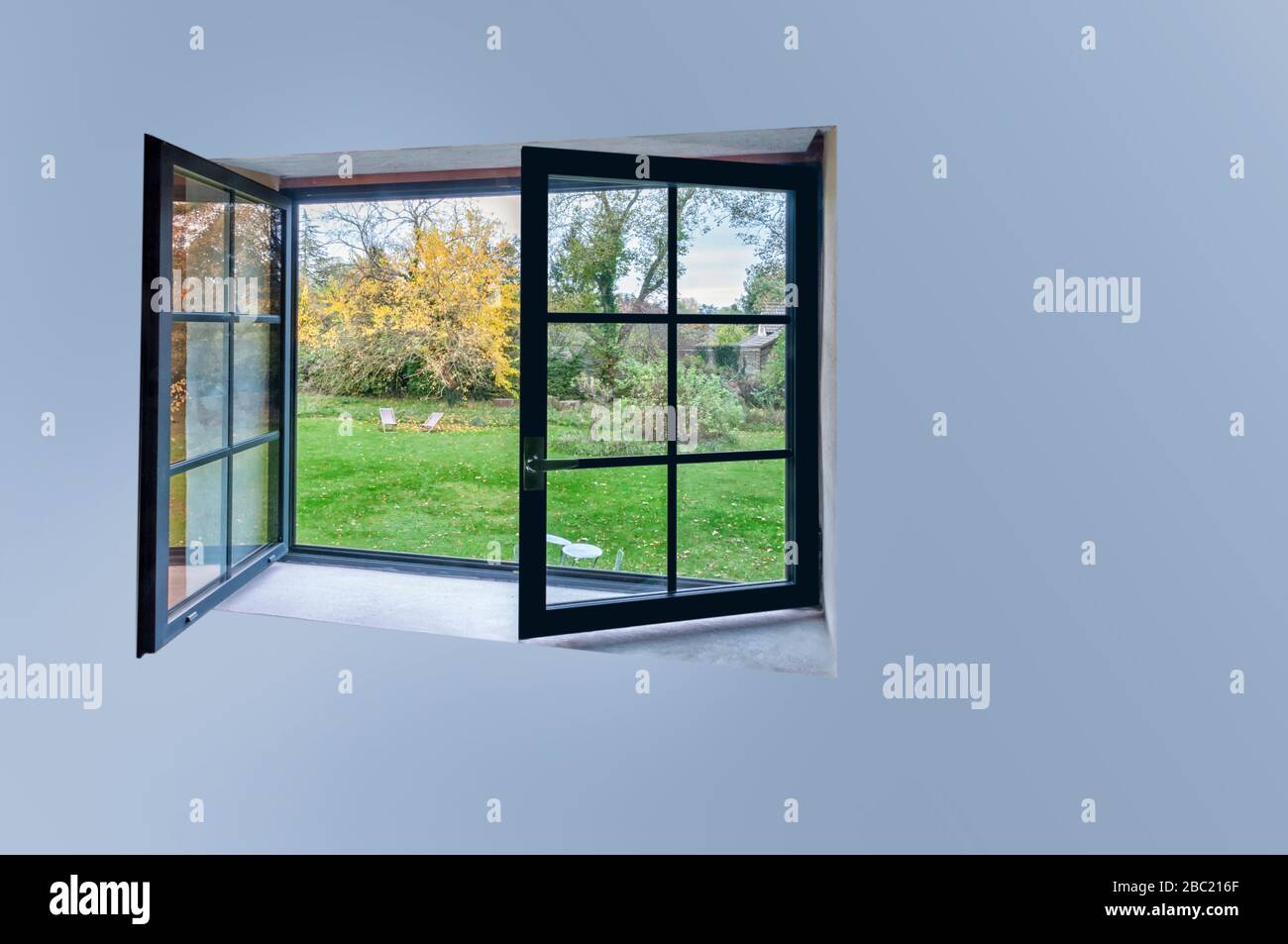 Large black aluminum open window with scenic nature view and copy space ...