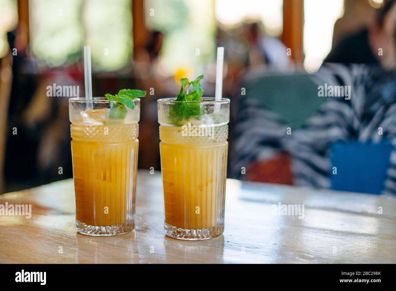 two glasses of fresh lemonade with ice on table in summer cafe Stock Photo